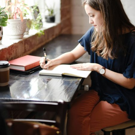 woman author writing at window dreamily - intentionallyflourish.com